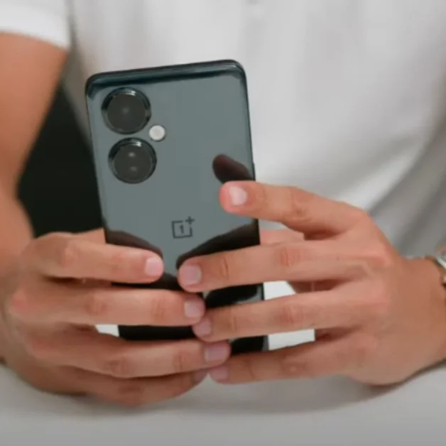 Person holding OnePlus Nord CE 3 Lite smartphone showing dual rear camera design.