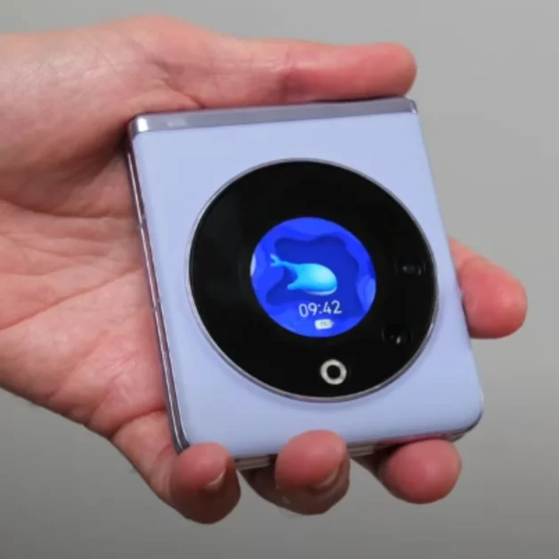 Hand holding Tecno Phantom V Flip smartphone with circular cover display.