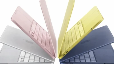 MacBook Neon laptops in four colors arranged in a symmetrical fan display on a clean white background.